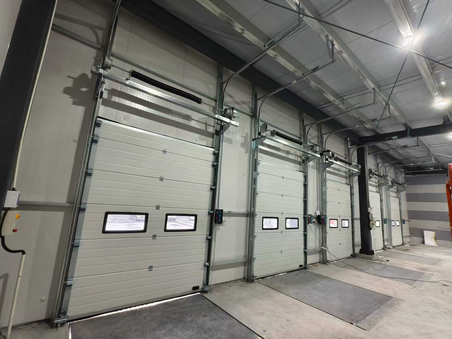 Lawang Sectional Industrial lan Dock Levelers Pangiriman kanggo Proyek Gudang